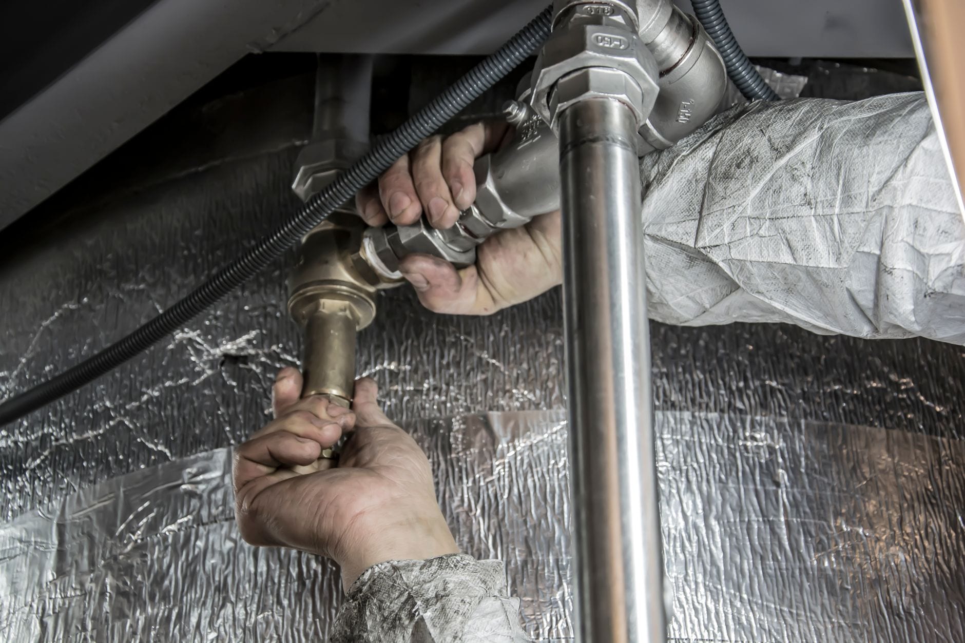 A plumber tightening a pipe fitting